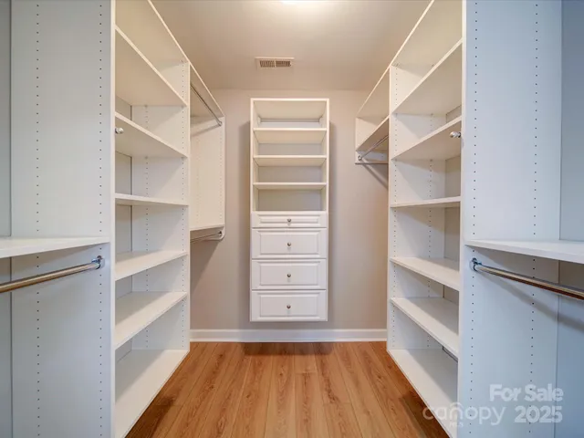 a view of walk in closet with empty racks