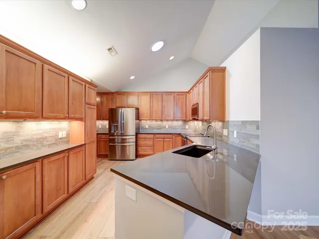 a kitchen with stainless steel appliances a sink stove and cabinets