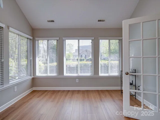 a view of a room with wooden floor and windows