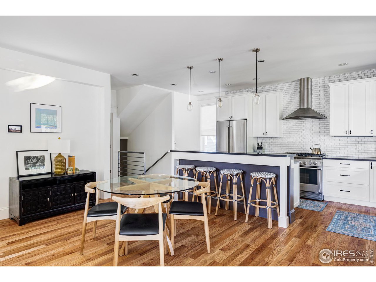 2129 23rd Street Boulder, CO 80302 - Photo 10 of 32 a open kitchen with granite countertop a stove a sink a dining table and chairs with wooden floor