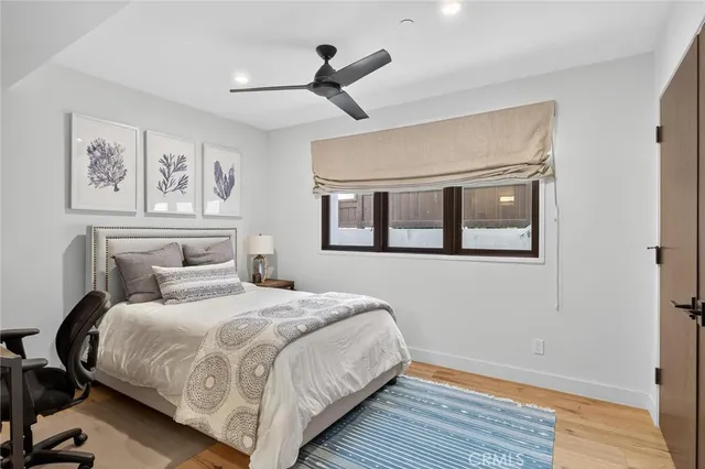 a bedroom with a large bed and a ceiling fan