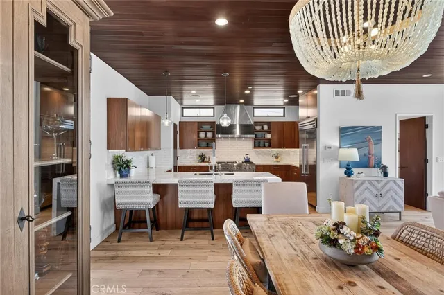 a room with stainless steel appliances lots of white furniture and a table