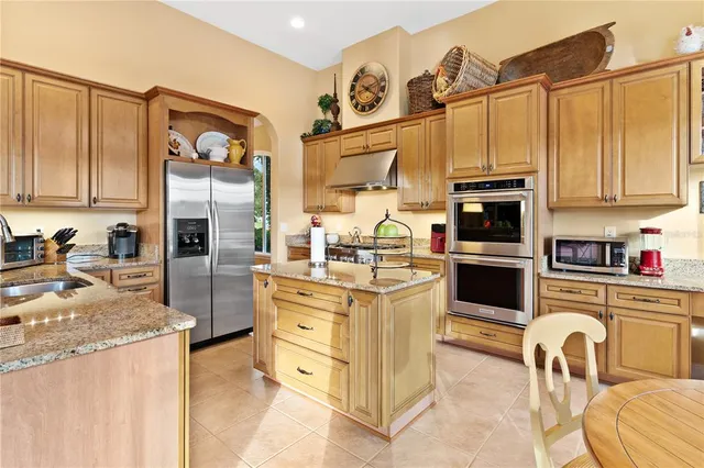 a view of a dining room with furniture a kitchen and chandelier