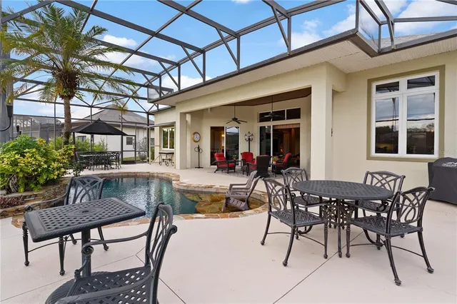 an aerial view of a house with swimming pool and large trees