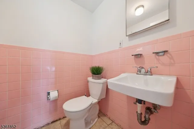 a bathroom with a sink toilet and a mirror