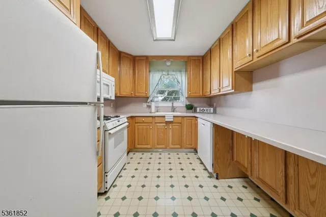 a kitchen with a sink a stove top oven cabinets and a refrigerator