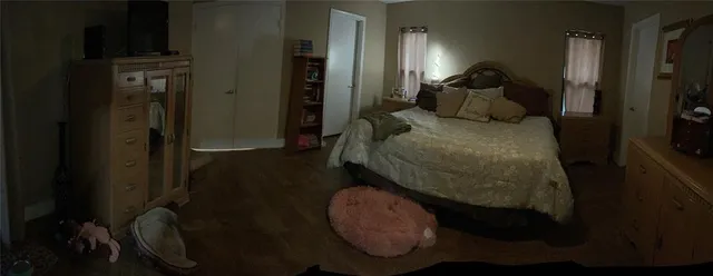 a bedroom with a bed next to a window