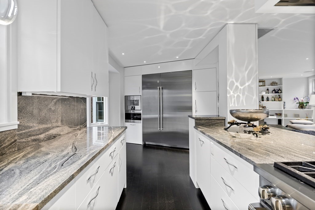 35 Wykeham Road Newton, MA 02465 - Photo 17 of 40 a large kitchen with kitchen island a large counter top a stove a sink and a refrigerator