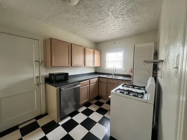 a kitchen with a stove a sink and a refrigerator