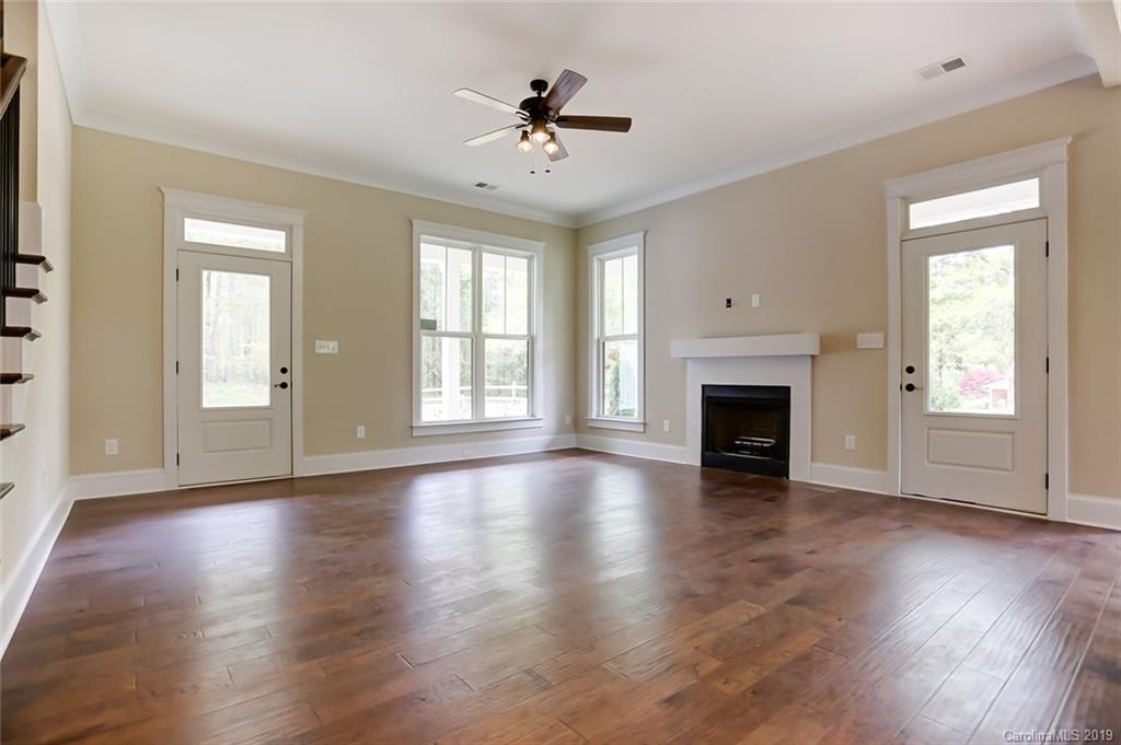 846 Union New Hope Road Gastonia, NC 28056 - Photo 6 of 41 an empty room with wooden floor a ceiling fan and windows