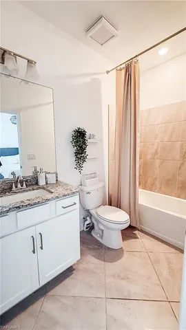 a bathroom with a granite countertop sink toilet a mirror and shower