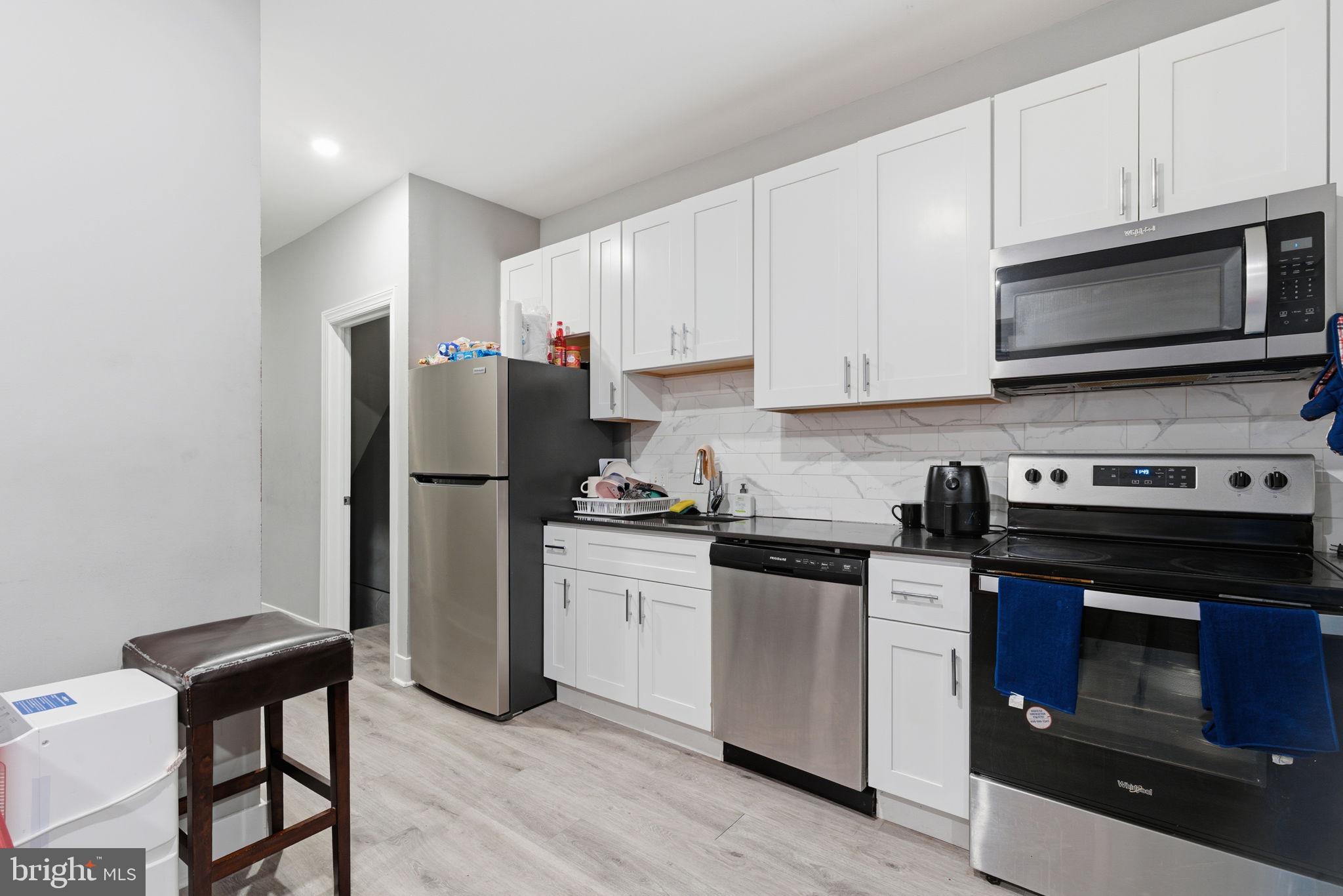 1813 South 23rd Street Philadelphia, PA 19145 - Photo 3 of 23 a kitchen with stainless steel appliances a stove a refrigerator and a microwave