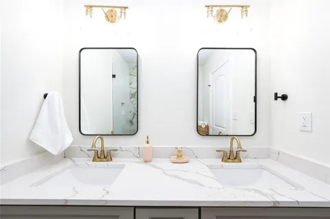 a bathroom with double vanity sinks and a mirror