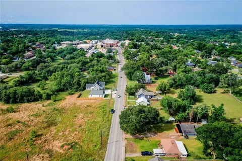an aerial view of residential houses with outdoor space and trees