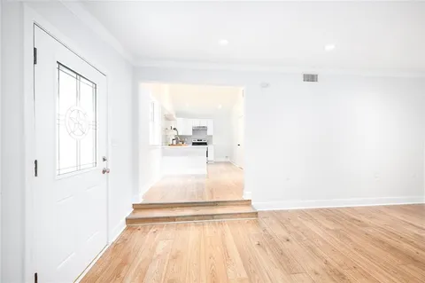 a view of a hallway with wooden floor and staircase