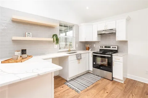 a kitchen with a sink a stove and cabinets