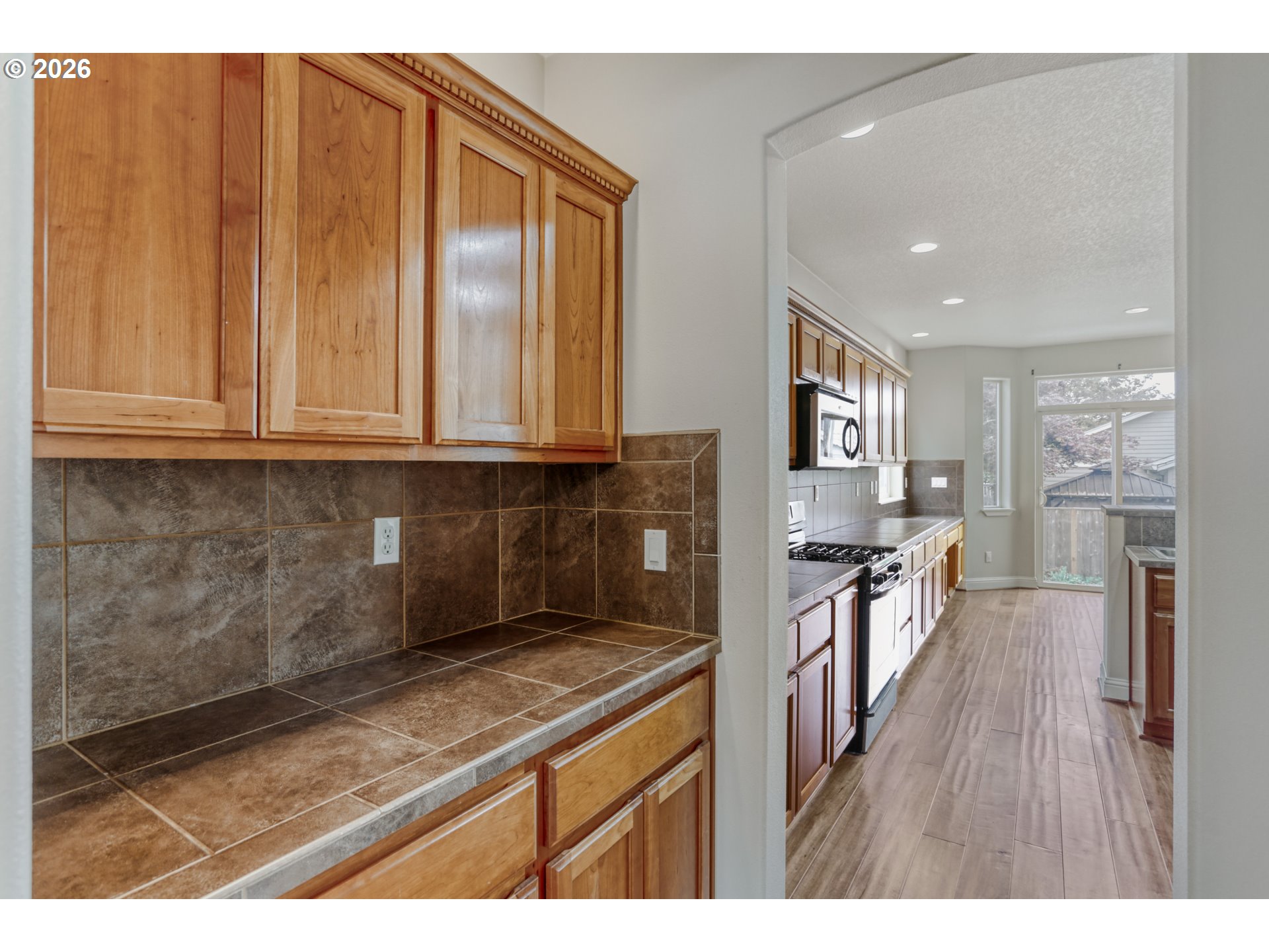 21533 Southwest Susan Lane Beaverton, OR 97003 - Photo 13 of 31 a kitchen with stainless steel appliances granite countertop a stove a sink dishwasher and a microwave with wooden floor