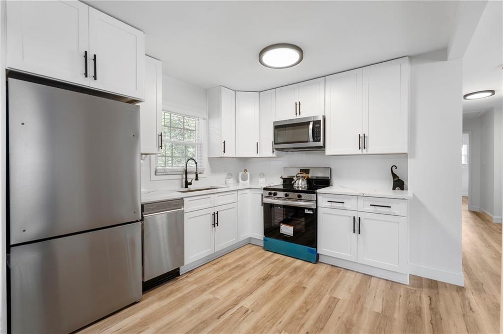 1969 Valley Ridge Drive Southwest Atlanta, GA 30331 - Photo 18 of 37 a kitchen with stainless steel appliances granite countertop a refrigerator stove a sink dishwasher and microwave with wooden floor