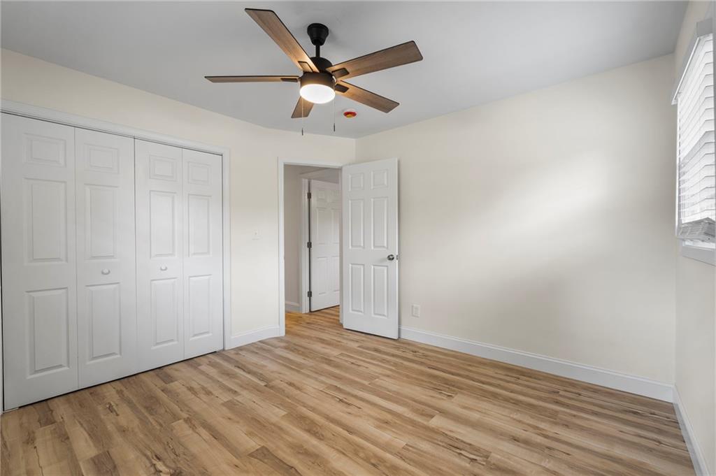 1969 Valley Ridge Drive Southwest Atlanta, GA 30331 - Photo 27 of 37 an empty room with wooden floor and a ceiling fan