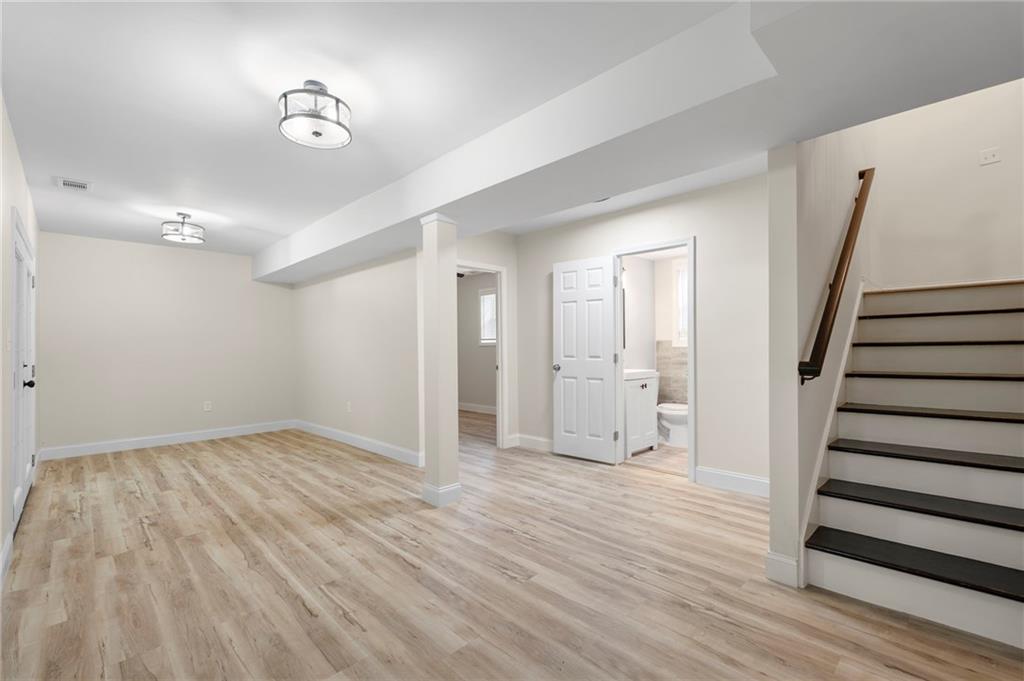 1969 Valley Ridge Drive Southwest Atlanta, GA 30331 - Photo 28 of 37 a view of an empty room with wooden floor and stairs