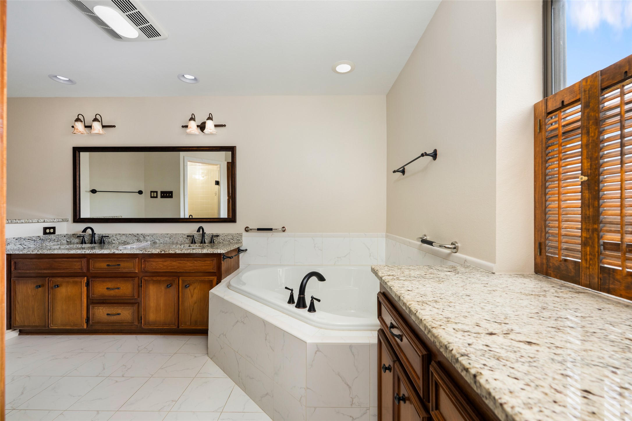 5319 Musket Ridge Austin, TX 78759 - Photo 20 of 39 Marble tile flooring and granite counters appoint this well-lit bathroom with a large soaking tub.