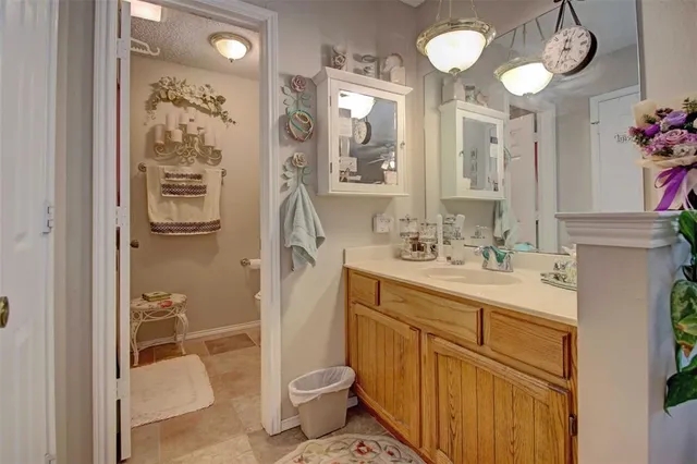 a bathroom with a granite countertop sink a toilet and shower