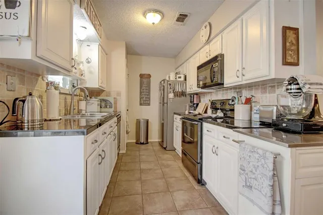 a kitchen with stainless steel appliances granite countertop a sink and cabinets