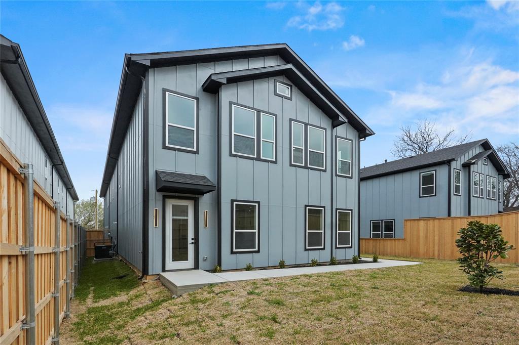 Rear view of house with board and batten siding and a fenced backyard