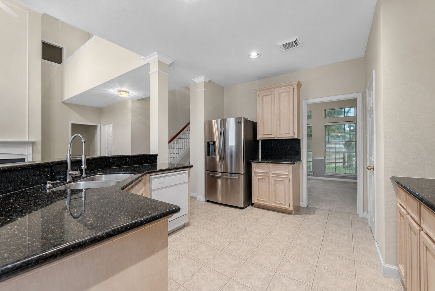 5724 Shady Hollow Court Rosharon, TX 77583 - Photo 7 of 27 Spacious kitchen featuring fresh paint throughout, neutral tones, and an open flow into the adjoining living and breakfast areas. The kitchen offers granite countertops, tile flooring, ample cabinetry, and stainless steel appliances. In addition to the water softener on the property, the homeowner also added a dedicated drinking water filter by the sink for added convenience. Clean, bright, and functional, this kitchen is ready for everyday living and entertaining.