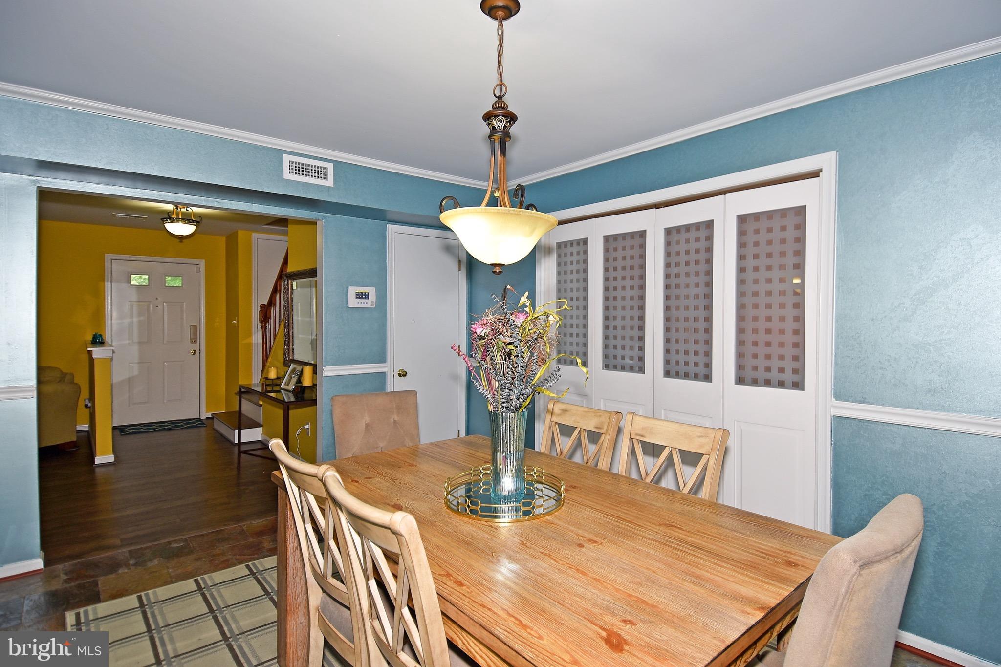 10313 Abbott Road Manassas, VA 20110 - Photo 5 of 30 a dining room with furniture a chandelier and wooden floor