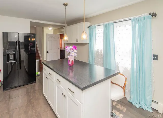 a kitchen with stainless steel appliances granite countertop a sink refrigerator and cabinets