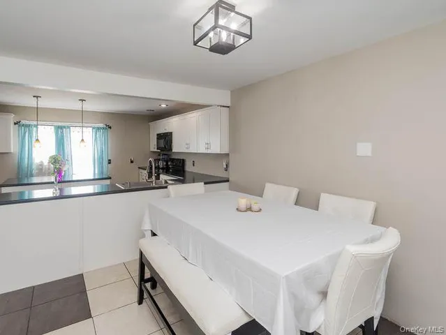 a kitchen with a dining table chairs and a refrigerator
