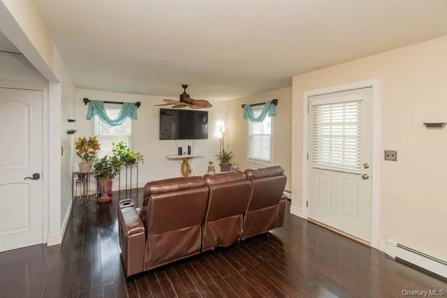 a living room with furniture a flat screen tv and a window