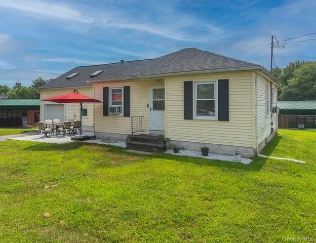 a front view of house with yard and outdoor seating