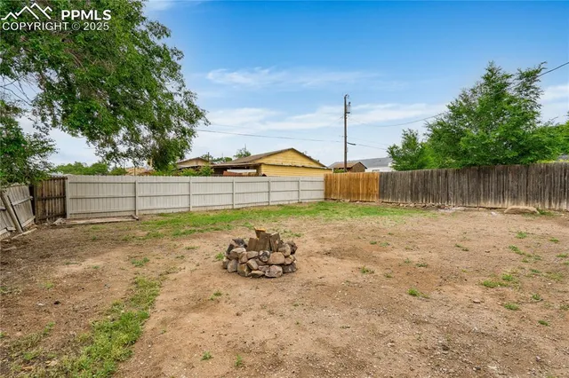 a view of a yard with wooden fence