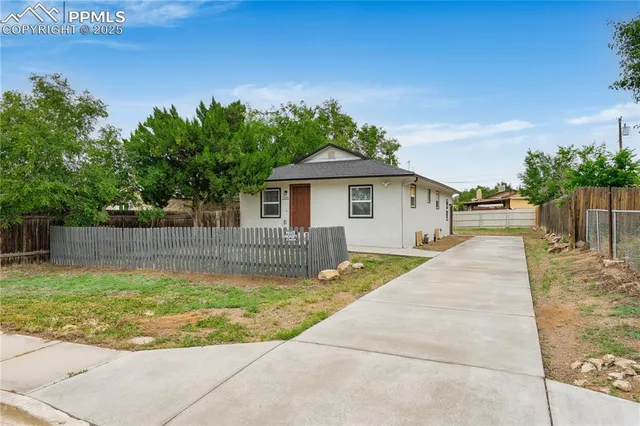 a view of a backyard with a fountain plants and large tree