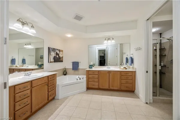 a large white bathroom with a granite countertop sink a mirror and a bathtub
