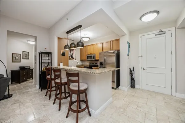 a kitchen with granite countertop a sink stove and refrigerator