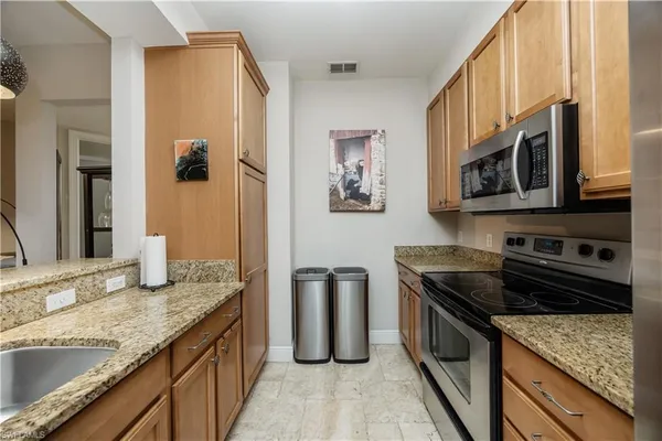 a kitchen with granite countertop a refrigerator and a sink