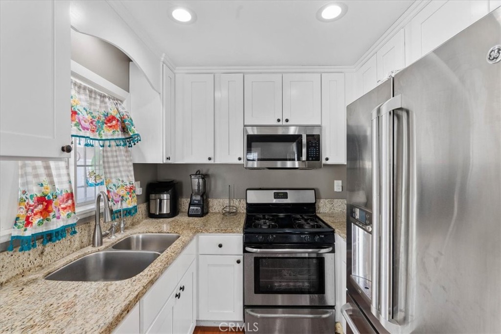 7167 Osbun Road San Bernardino, CA 92404 - Photo 27 of 35 a kitchen with stainless steel appliances granite countertop a sink stove and refrigerator