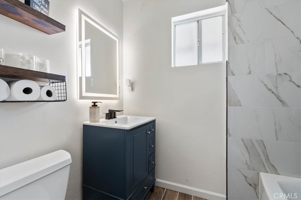 7167 Osbun Road San Bernardino, CA 92404 - Photo 3 of 35 a bathroom with a sink a toilet and a mirror