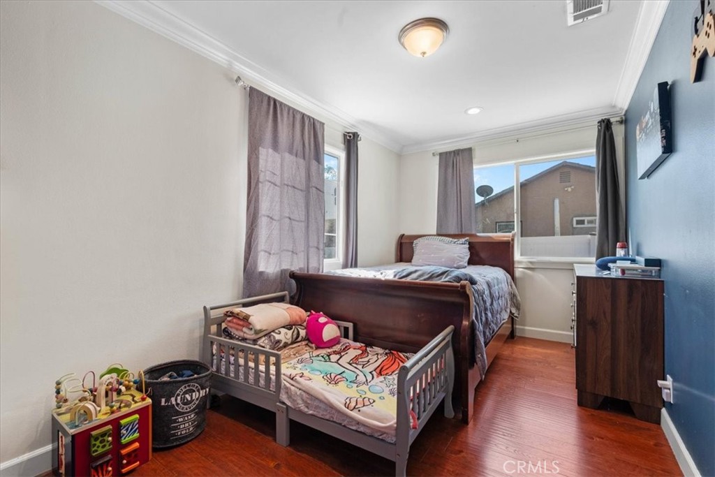 7167 Osbun Road San Bernardino, CA 92404 - Photo 33 of 35 a bedroom with a bed and wooden floor