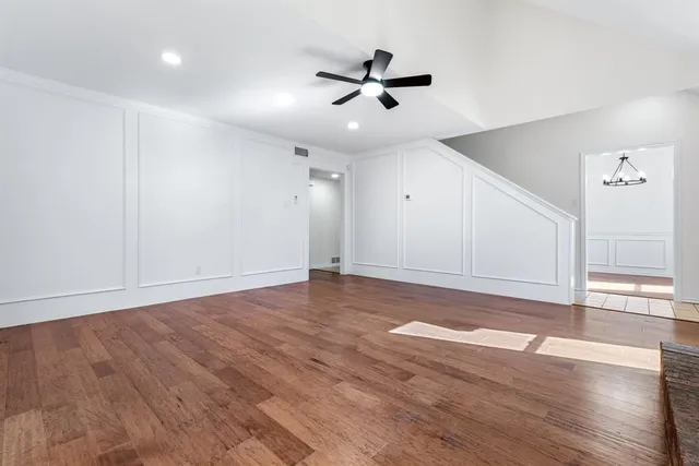 a view of a livingroom with wooden floor and a ceiling fan