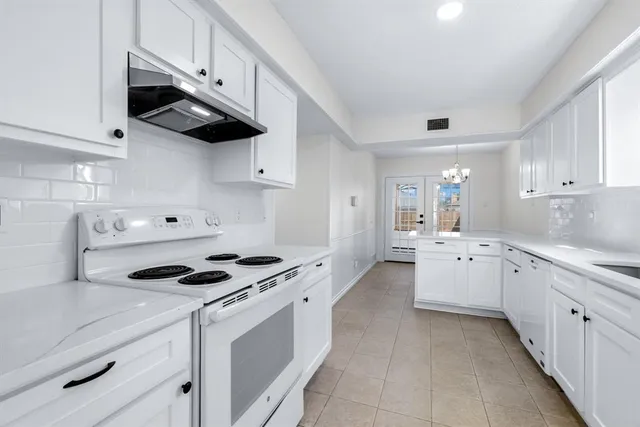 a kitchen with stainless steel appliances a white stove top oven and cabinets