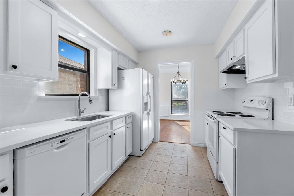 2543 Sundance Lane Dallas, TX 75287 - Photo 10 of 27 a kitchen with stainless steel appliances a sink stove and cabinets