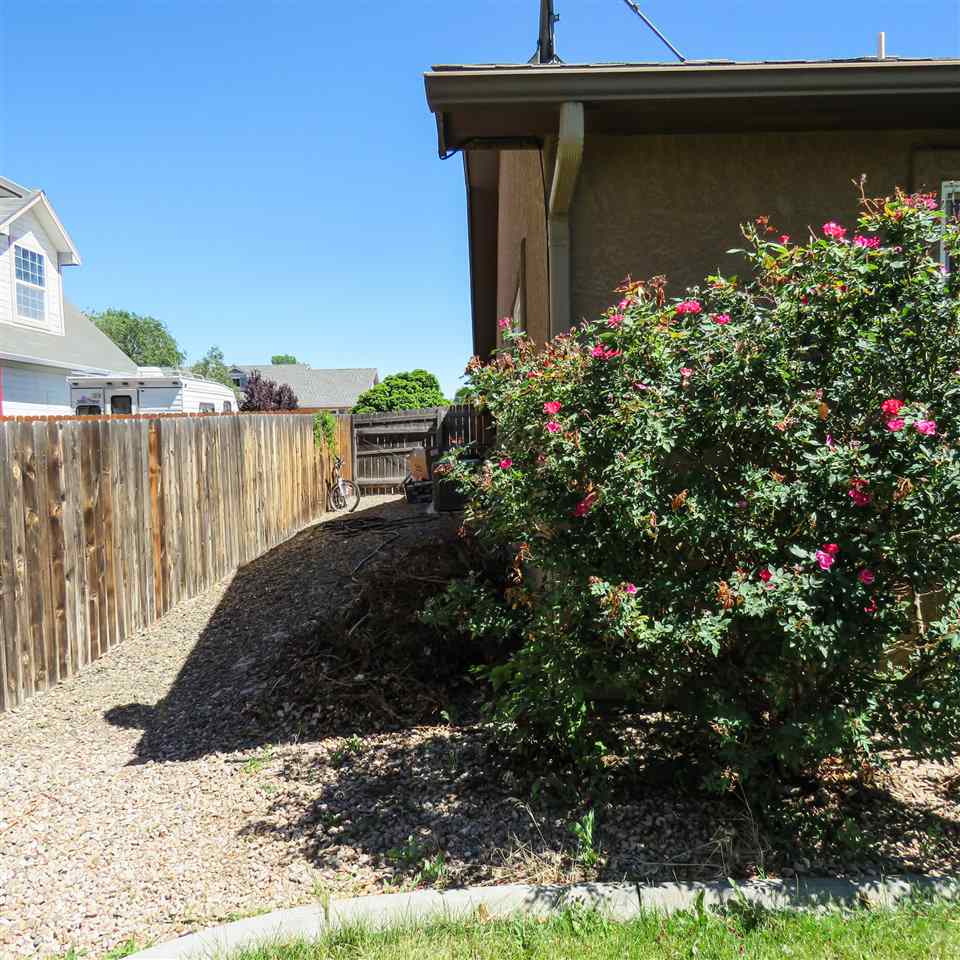 983 Kaley Street Fruita, CO 81521 - Photo 13 of 28 a front view of a house with a big yard and potted plants