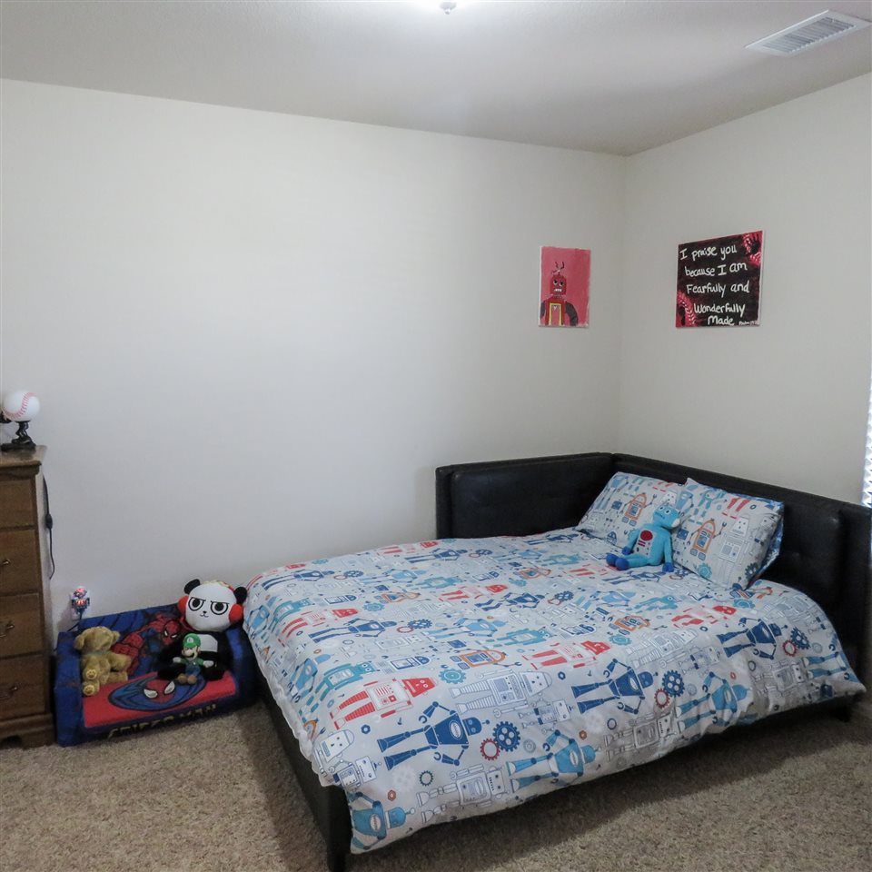 983 Kaley Street Fruita, CO 81521 - Photo 2 of 28 a bedroom with a bed and a dresser in it