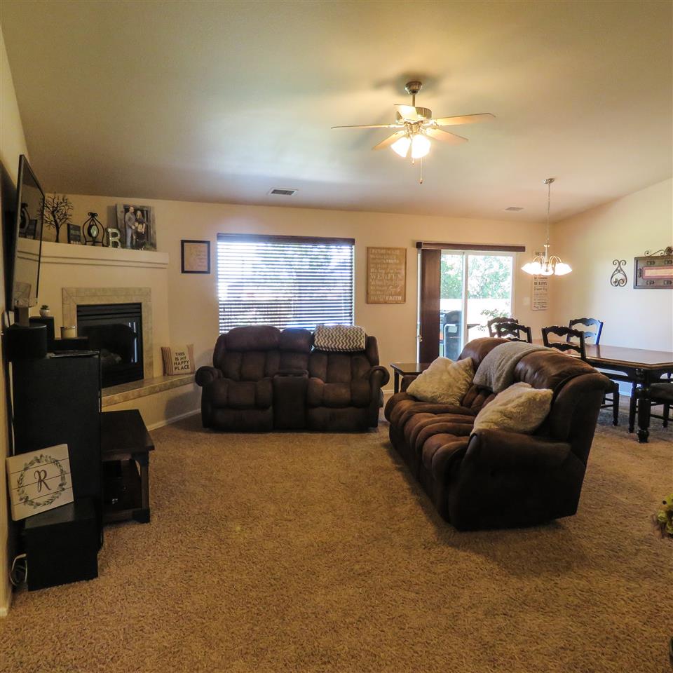 983 Kaley Street Fruita, CO 81521 - Photo 22 of 28 a living room with furniture a fireplace and a chandelier