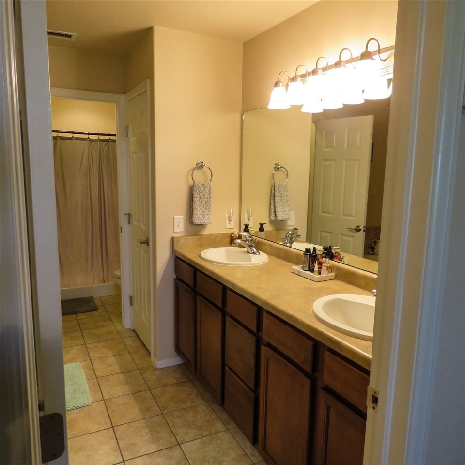 983 Kaley Street Fruita, CO 81521 - Photo 26 of 28 a bathroom with a double vanity sink a mirror and a shower