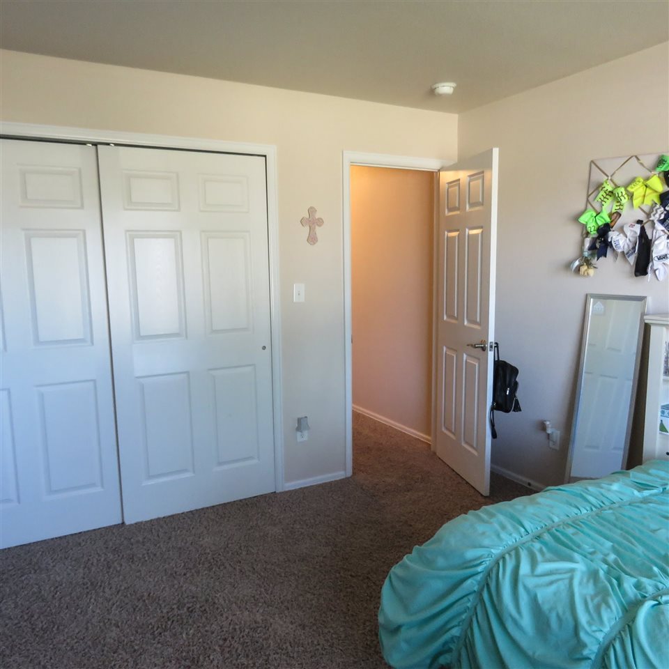 983 Kaley Street Fruita, CO 81521 - Photo 6 of 28 a bedroom with a bed and hallway